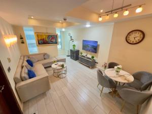 a living room with a couch and a table and a clock at One Bedroom apartment Centaurus Islamabad in Islamabad
