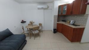 a living room with a couch and a table and a kitchen at גאון מול המדבר in Arad +2 photos