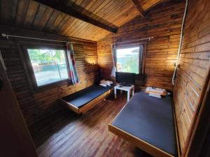 a room with two beds in a wooden cabin at Domek "Sen 100 Jezior" in Chrzypsko Wielkie