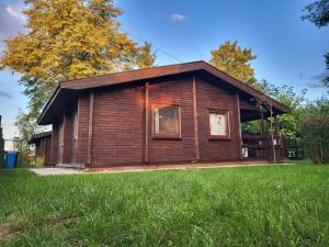 a small log cabin in a field of grass at Domek "Sen 100 Jezior" in Chrzypsko Wielkie