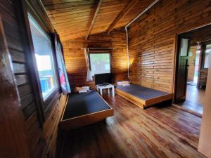 a room with two beds in a wooden cabin at Domek "Sen 100 Jezior" in Chrzypsko Wielkie +26 photos