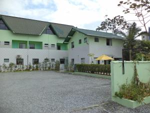 a building with a parking lot in front of it at Hotel Pousada Reimar in Balneário Camboriú