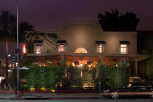 a car parked in front of a building at night at The Crescent Hotel Beverly Hills in Los Angeles