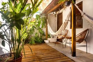 a porch with hammocks and potted plants at La hospedaria in Trancoso