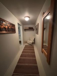 a hallway with a staircase with a mirror and a bed at Studio Sillankorva in Viitasaari
