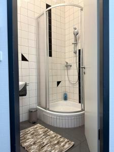 a bathroom with a shower and a bath tub at Monteur- und Ferienunterkunft Ludwigsfelde in Ludwigsfelde