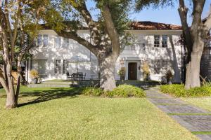 a white house with trees in front of it at Stylish Dallas Condo Resort-Style Pool in Dallas