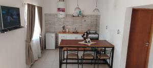 a kitchen with a table and some chairs in it at Cabaña de campo La Tabanerina in Salto de las Rosas