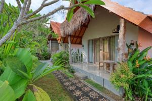 a view of a house with a thatched roof at Cassava Penida Cottage in Nusa Penida