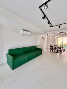 a green couch in a living room with a table at Pipa Sunset Mansion in Pipa