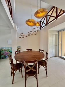 a dining room with a wooden table and chairs at Pipa Sunset Mansion in Pipa