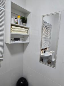 a white bathroom with a mirror and a sink at Zachi Eland Apartment in Kitwe