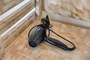 a black hair dryer sitting on a wooden floor at Cassava Penida Cottage in Nusa Penida