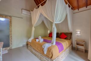 a bedroom with a bed with a canopy at Cassava Penida Cottage in Nusa Penida