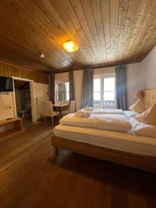 a bedroom with a large bed with a wooden ceiling at LAKE & RIVER Hotel in Carezza al Lago