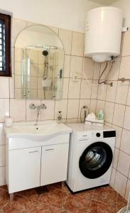 a bathroom with a washing machine and a sink at Apartments Happy Day in Karlobag