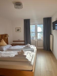 a bedroom with two beds with towels on them at LAKE & RIVER Hotel in Carezza al Lago