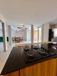a kitchen with a stove and a dining room at Pipa Sunset Mansion in Pipa +24 photos