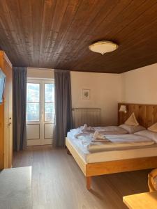 a bedroom with a large bed and a wooden ceiling at LAKE & RIVER Hotel in Carezza al Lago +17 photos