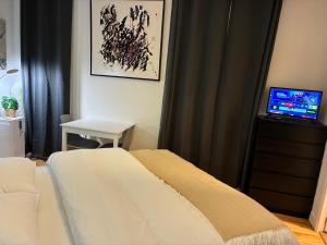 a bedroom with a bed and a desk with a television at Studio number 3 in Pantin