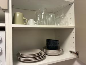a cabinet filled with plates and bowls and glassware at Studio number 3 in Pantin +16 photos