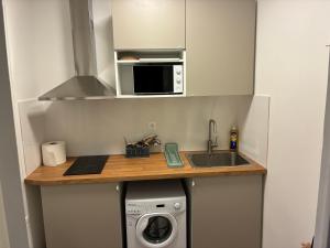 a small kitchen with a sink and a washing machine at Studio number 3 in Pantin