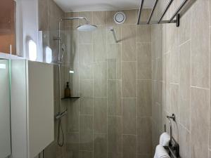 a shower with a glass door in a bathroom at Studio number 3 in Pantin