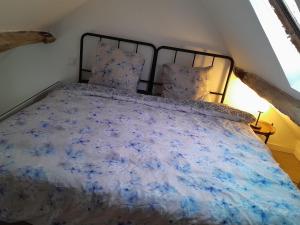 a bedroom with a bed with a blue comforter at Escapade & Bien être in Ravenel