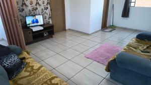 a living room with a couch and a tv at Pousada RC Q2 in Várzea Grande +1 photo