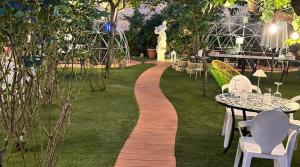 a walkway in a garden with tables and chairs at Proserpina in Enna