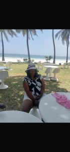 a woman sitting on a bench at the beach at Wrens cosy home in Diani Beach +14 photos