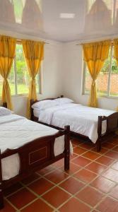 a bedroom with two beds and two windows at Casa sendai2 in Buesaco