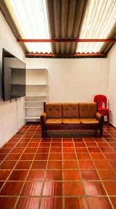 a couch sitting in a room with a television at Casa sendai2 in Buesaco