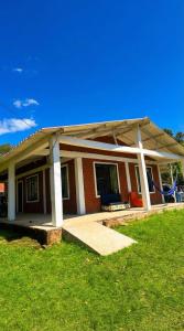 a small house with a porch and a grass yard at Casa sendai2 in Buesaco +3 photos