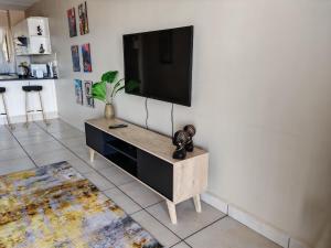 a living room with a tv on a wall at Vene's Place in Mossel Bay