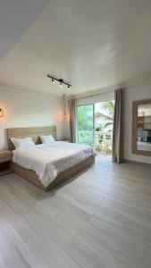 a bedroom with a large bed and a large window at Hotel Juan Dolio in Juan Dolio
