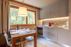 a kitchen with a table and chairs and a window at SWISSPEAK Resorts by Pierre & Vacances Premium Zinal in Zinal