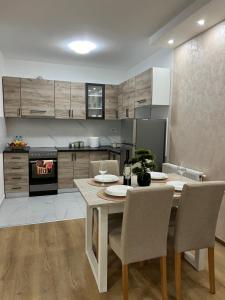 eine Küche mit Tisch und Stühlen in einem Zimmer in der Unterkunft Gold Star Apartman in Ruma + 11 Fotos