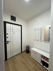 ein Badezimmer mit einem großen Spiegel und einer weißen Wand in der Unterkunft Gold Star Apartman in Ruma
