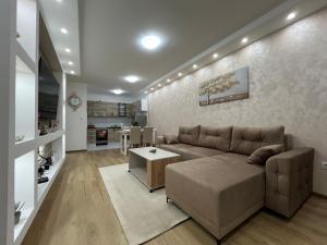 ein Wohnzimmer mit Sofa und Tisch in der Unterkunft Gold Star Apartman in Ruma
