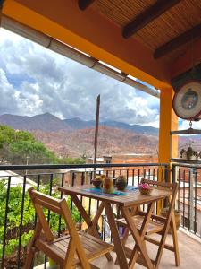 a table and chairs on a balcony with a view at Casa Mamani in Tilcara