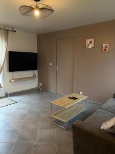 a living room with a couch and a table at Jardin des prés in Le Thil-en-Vexin