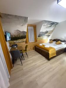 a bedroom with a bed and a desk and a painting at Willa Bafijówka in Groń