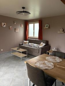 a living room with a couch and a table at Jardin des prés in Le Thil-en-Vexin