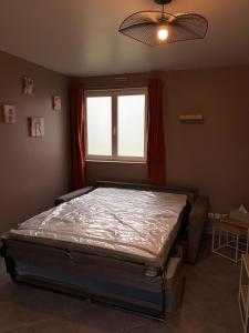 a bed in a room with a window at Jardin des prés in Le Thil-en-Vexin