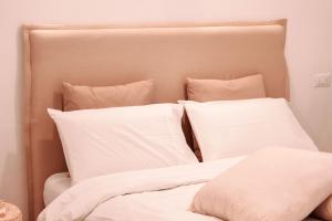 a bed with white sheets and pillows at Dimora Caggione in Polignano a Mare