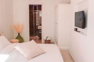 a white room with a white couch and a television at Dimora Caggione in Polignano a Mare
