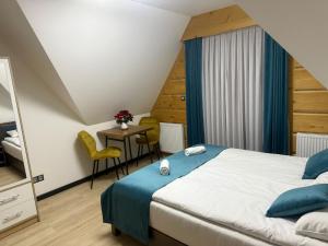 a bedroom with a bed and a table and chairs at Willa Bafijówka in Groń +52 photos