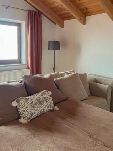 a couch with a pillow on it in a living room at Servus Chiemgau - Große Wohnung mit Bergblick in Frasdorf