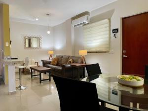 a living room with a couch and a table at Charming Condo in Gaviotas Walk to Beach cafes, restaurants within Golden Zone in Mazatlán